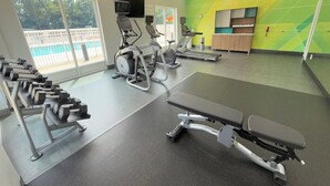 A gym with treadmills, elliptical machines, and dumbbells. - Holiday Inn & Suites Fayetteville W-Fort Bragg Area by IHG (Fayetteville)