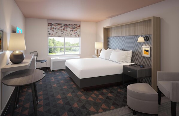 A hotel room with a bed, bedside tables, a desk, a chair, and a window with a view of trees.