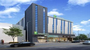 Un hotel Holiday Inn Express con un diseño moderno, que destaca por su fachada vertical y amplias ventanas.
