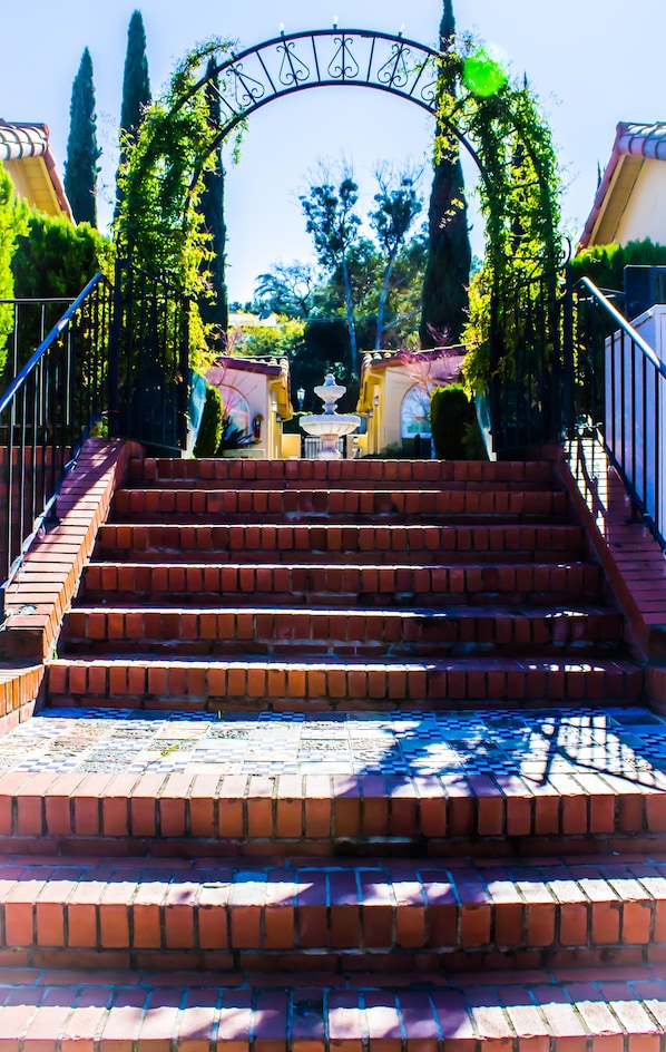 A set of brick stairs leading up to a gate with a decorative arch. - Los Gatos Garden Inn Hotel (Los Gatos)