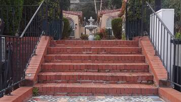 A set of brick stairs leading up to a gated entrance with a decorative archway.