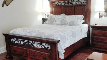 Una camera da letto con un letto in legno, due comodini, un tavolino e un decoro a parete.