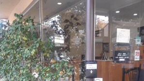 A building with a glass facade, a sign for 'Garden Inn Lobby & Business Center', and a blue pet bowl on the ground. - Los Gatos Garden Inn Hotel (Los Gatos)