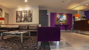 Ein modernes Wohnzimmer mit einer Couch, Sesseln, einem Couchtisch und einem Teppich.