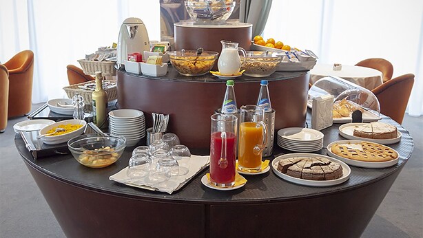 Ein reichhaltiges Frühstücksbuffet mit verschiedenen Speisen und Getränken auf einem runden Tisch.