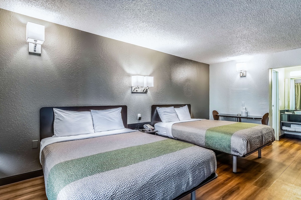 Une chambre d’hôtel avec deux lits, une petite table et une chaise.