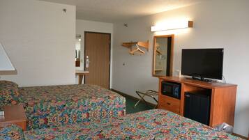 Une chambre d’hôtel avec deux lits, une télévision, un réfrigérateur et une armoire en bois.