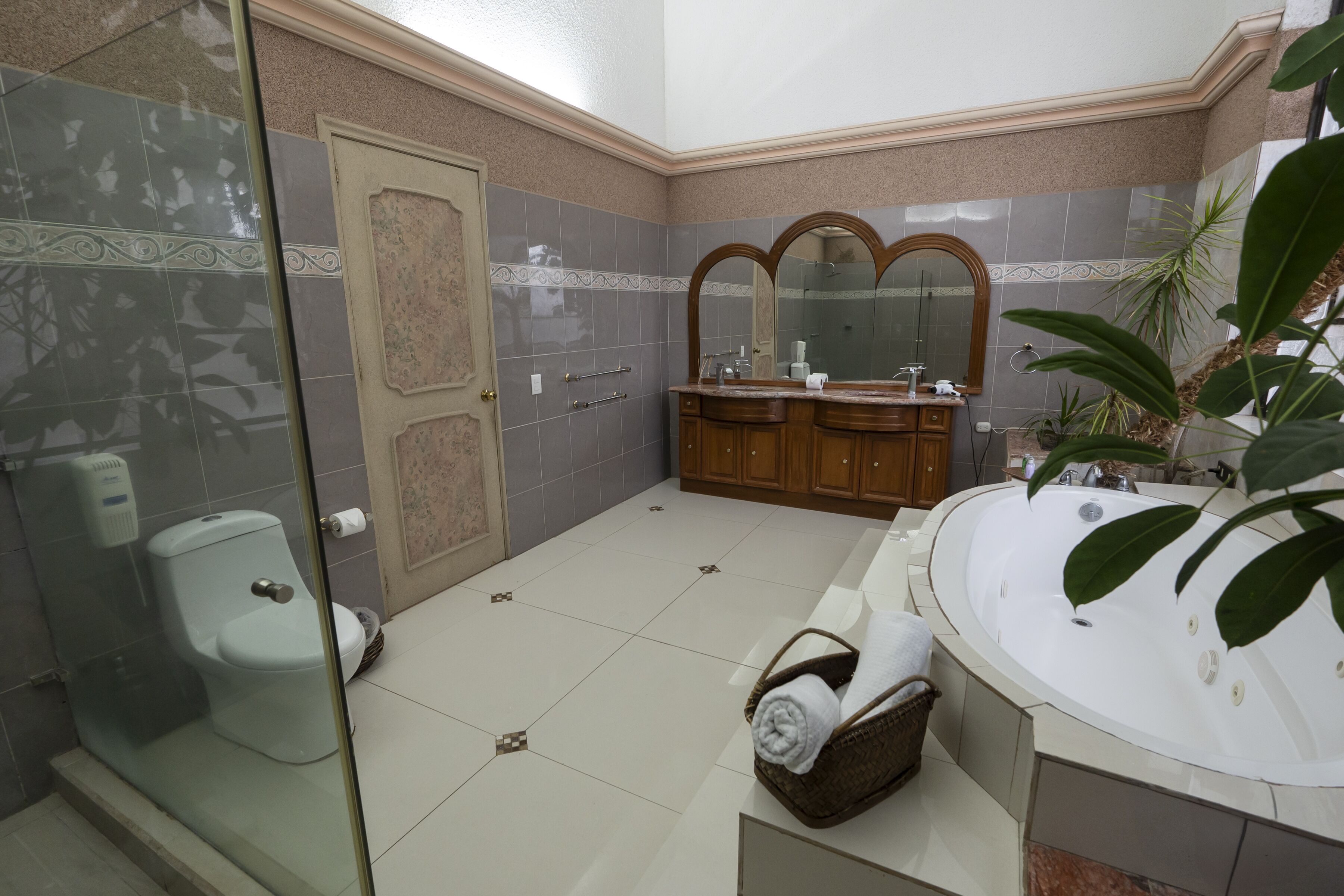 Ein Badezimmer mit einer Duschkabine, einer Badewanne und einem Waschtisch mit Spiegel.