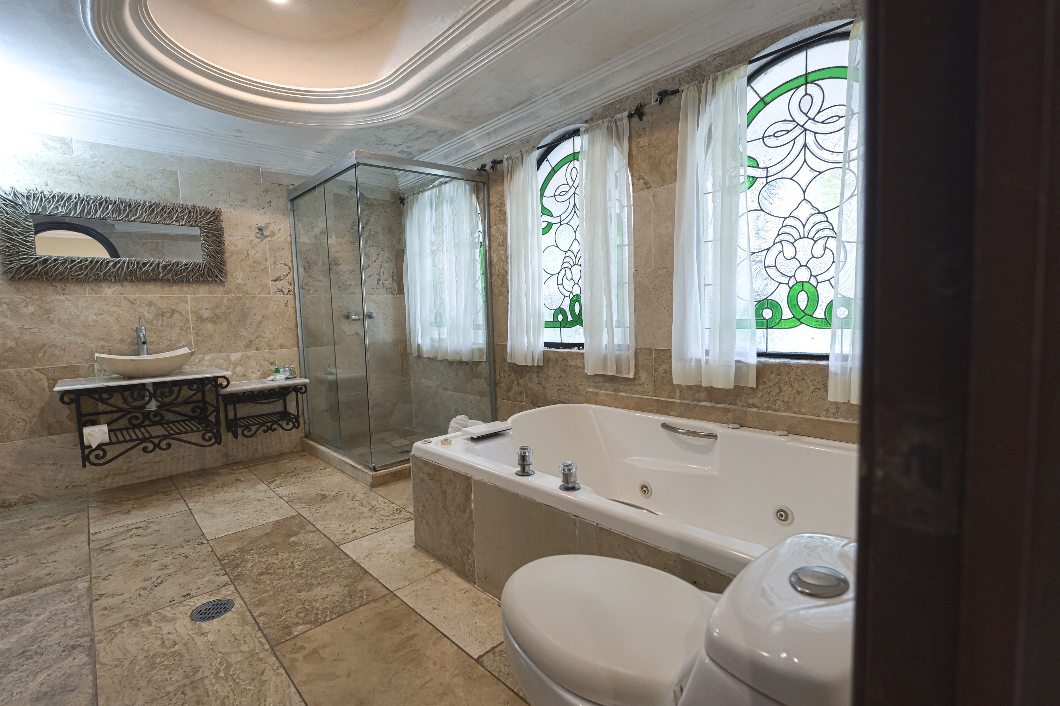 A modern bathroom with a freestanding bathtub, a glass-enclosed shower, and a vanity with a sink and mirror.