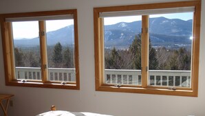 A bedroom with two windows overlooking a mountainous landscape. - Sunny Condo w/ Outlet Shops, Expansive Mountain, Valley Views Near North Conway (Intervale)