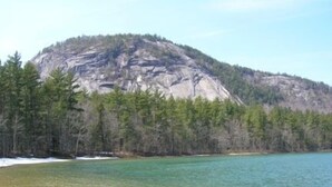 A clear view of a lake surrounded by a forested mountain. - Sunny Condo w/ Outlet Shops, Expansive Mountain, Valley Views Near North Conway (Intervale)