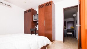 A bedroom with a bed, wardrobe, TV, desk, and chair. - Lovely Kingsize-bed Studio, amazing rooftop with pool, best location (unit 203) (Playa del Carmen)