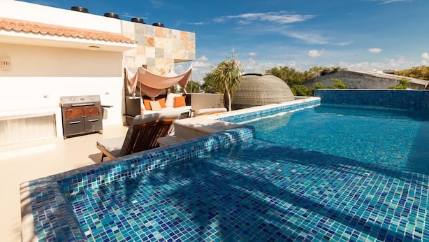 A swimming pool with blue mosaic tiles, a barbecue area, and a covered seating area. - Lovely Kingsize-bed Studio, amazing rooftop with pool, best location (unit 203) (Playa del Carmen)