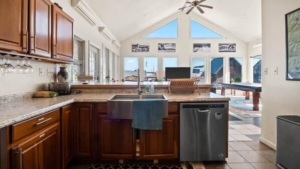 A kitchen with wooden cabinets, a stainless steel sink, and a dishwasher.