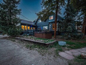 Een huis met twee verdiepingen, een zichtbaar terras en een hottub in de tuin.