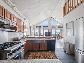 Una cocina amplia con una isla grande, electrodomésticos modernos y vistas al exterior.