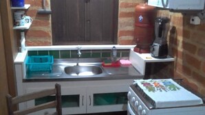 Une cuisine de taille réduite, équipée d’un évier, d’une cuisinière et d’un four à micro-ondes.