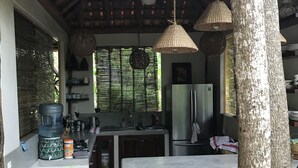 Una cocina con una isla grande, un refrigerador y luces colgantes.