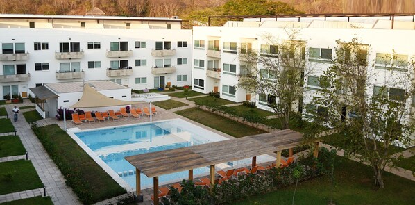 En modern byggnad med en swimmingpool, utomhusplats och en täckt uteplats.