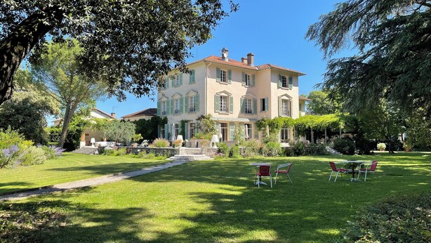 A large, two-story building with a garden in front. There are outdoor seating areas with chairs and tables. - Maison d'hôtes Le Parc (Labruguiere)