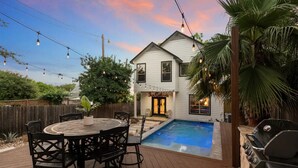 A two-story house with a swimming pool, outdoor seating, and string lights. - Single Malt Manor | Downtown Austin (Austin)