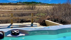A hot tub with a wooden deck and a view of mountains. - Beautiful, Stylish and Unique Cabin with Hot Tub close to Snæfellsjökull Glacier (Borgarnes)