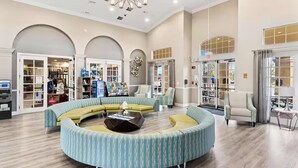 A spacious lobby with a curved seating area, a chandelier, and a bookstore.