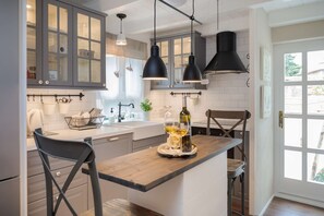 A kitchen with a wooden island, pendant lights, and a view through a door. - Apartment for 6 persons, 3 Bedrooms, 3 Bathrooms, Private Garden (Split)