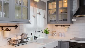 Una cocina moderna con armarios grises, encimera blanca y campana extractora negra.
