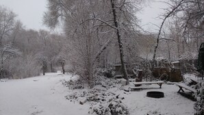 A snow-covered outdoor area with benches and a fire pit.