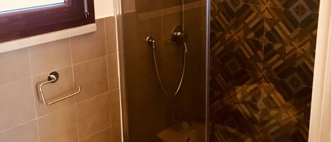 A bathroom with a glass shower enclosure, a sink, and a toilet.