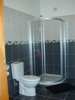 Een bad/douchecombinatie, een haardroger, een bidet, handdoeken