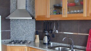 A kitchen with granite countertops, wooden cabinets, a stainless steel sink, and a dishwasher.