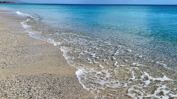 A beach with clear turquoise water, pebbly shore, and distant land. -  Beachfront Villa with spacious garden and direct beach access  (San Sostene Marina)