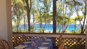 A table set for dining with a view of the sea and trees. -  Beachfront Villa with spacious garden and direct beach access  (San Sostene Marina)
