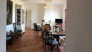 A dining area with a table, chairs, and a hanging light fixture. - "BLUE HOUSE" beautiful semi-detached villa with breathtaking views (PORTO SANTO STEFANO MONTE ARGENTARIO (GR)