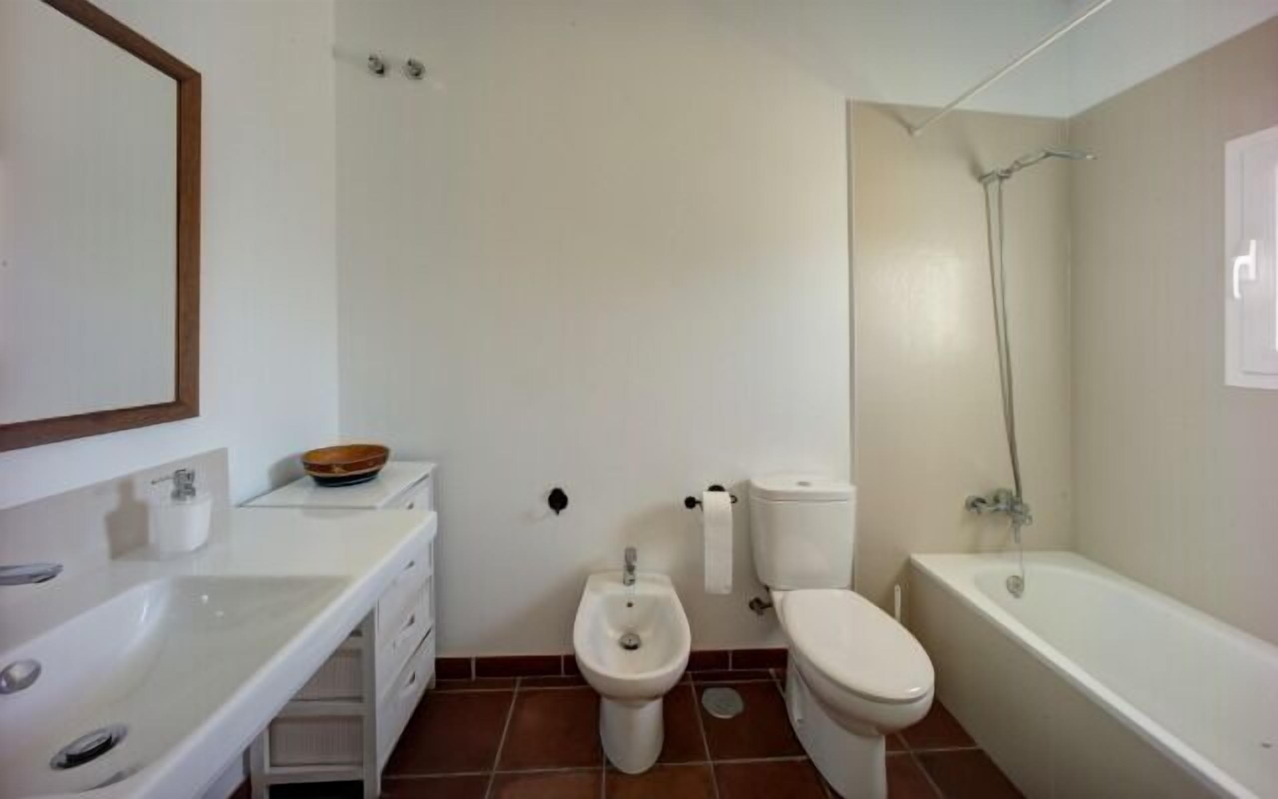 Un bagno con lavandino, bidet, WC e vasca da bagno.