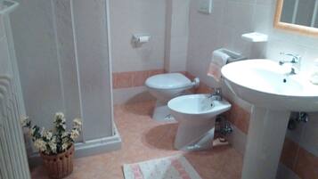 Ein Badezimmer mit Toilette, Bidet und Waschbecken.