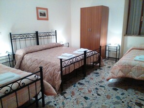 Ein Schlafzimmer mit einem Bett, einem Kleiderschrank und einem kleinen Tisch.