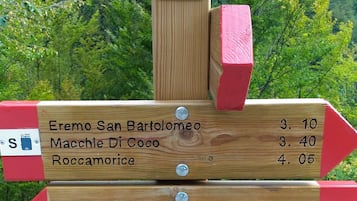 A wooden directional signpost with multiple arrows pointing to various destinations and their distances in kilometers.