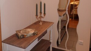 A wooden console table with a map and a candelabra with three candles. - Páteo dos Oliveira - Casa dos Serviçais (Évora)