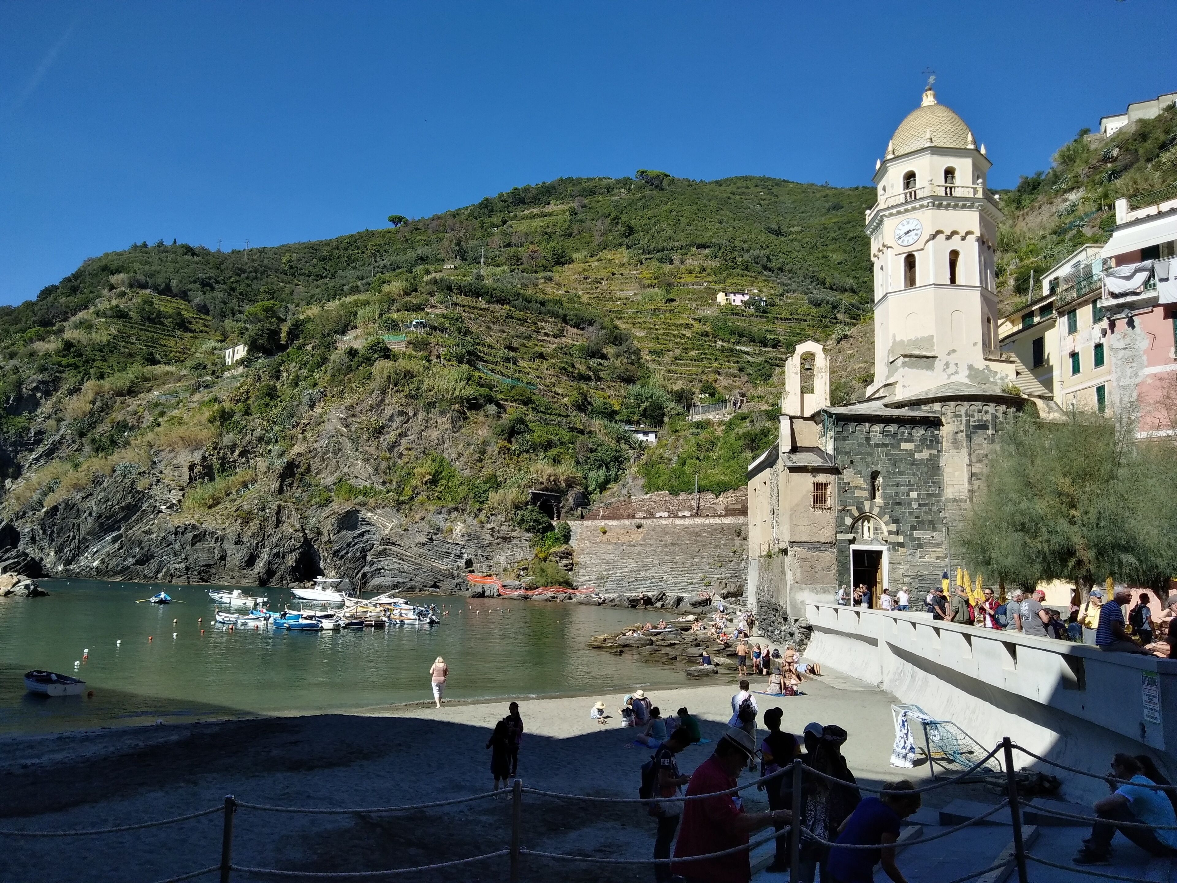 A coastal area with a church, a rocky shoreline, and boats.