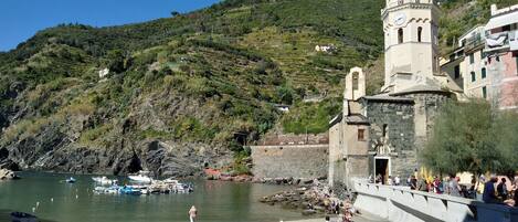 A coastal area with a church, a rocky shoreline, and boats.