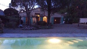 Uma casa com piscina, jardim e entrada para carros.