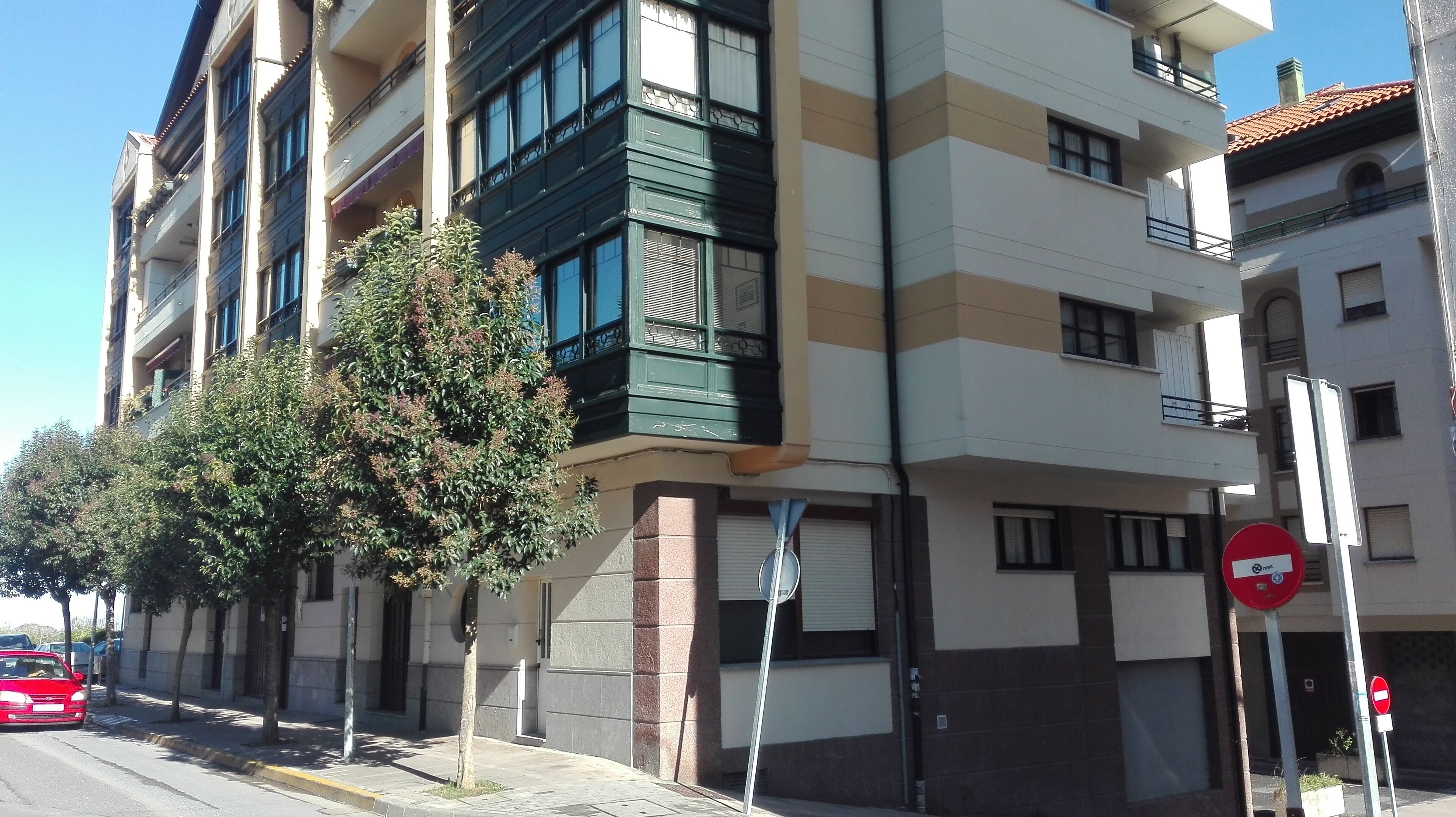 A multi-story building with a modern architectural design, featuring balconies and large windows.