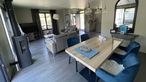 A modern living space with a dining area, sofa, and a fireplace. - House for 4/5 people, beaches and shops 400 m away (Arradon)
