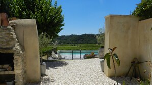 Ein Weg, der zu einem Pool mit Blick auf einen Weinberg und Hügeln im Hintergrund führt.