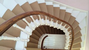 Una escalera de caracol con peldaños blancos y barandilla de madera.