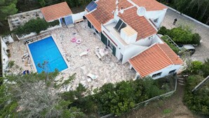 A two-story house with a swimming pool, outdoor seating, and a garden. - Beautiful Spacious Villa in 2,5 Acres A/C Heated Pool Nr Golf & Beaches Sleeps 8 (Budens near VILA DO BISPO)