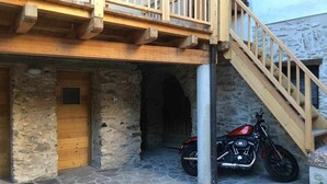 Ein Steinhaus mit einer Holztür und einem Motorrad davor.